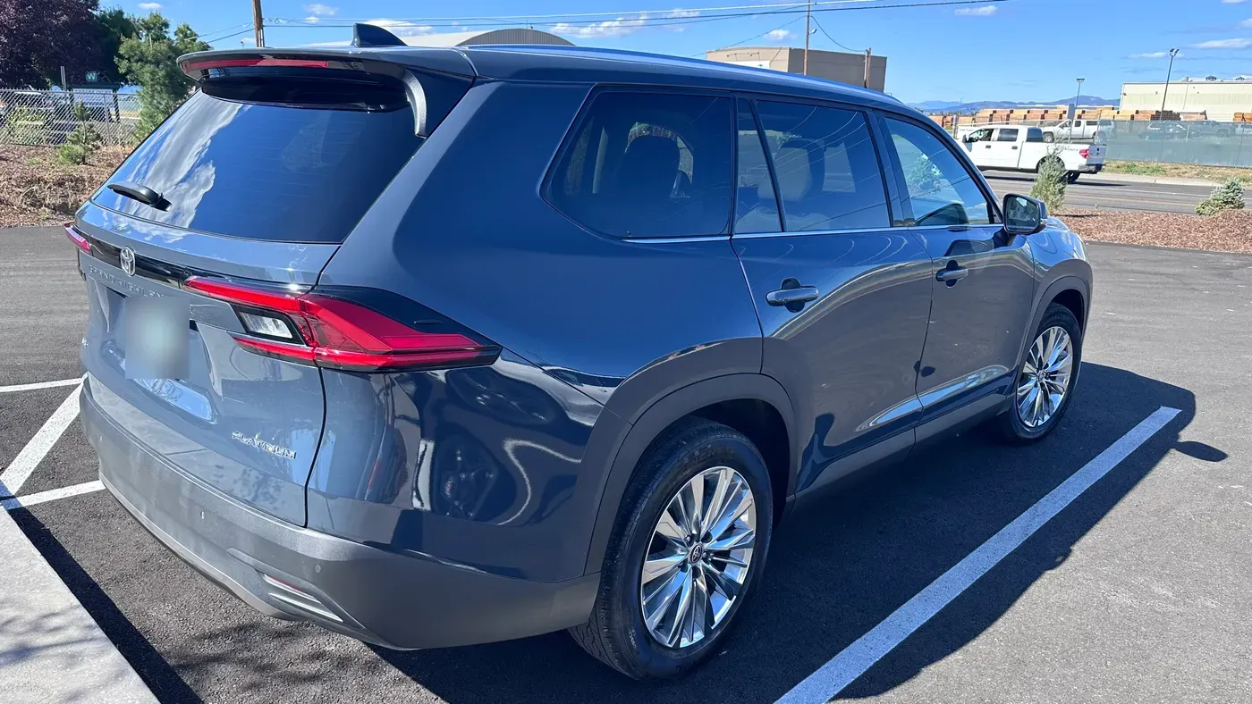 The same blue Toyota Grand Highlander Platinum with the rear quarter panel repaired, parked in the Sky Auto Body lot in Medford, Oregon